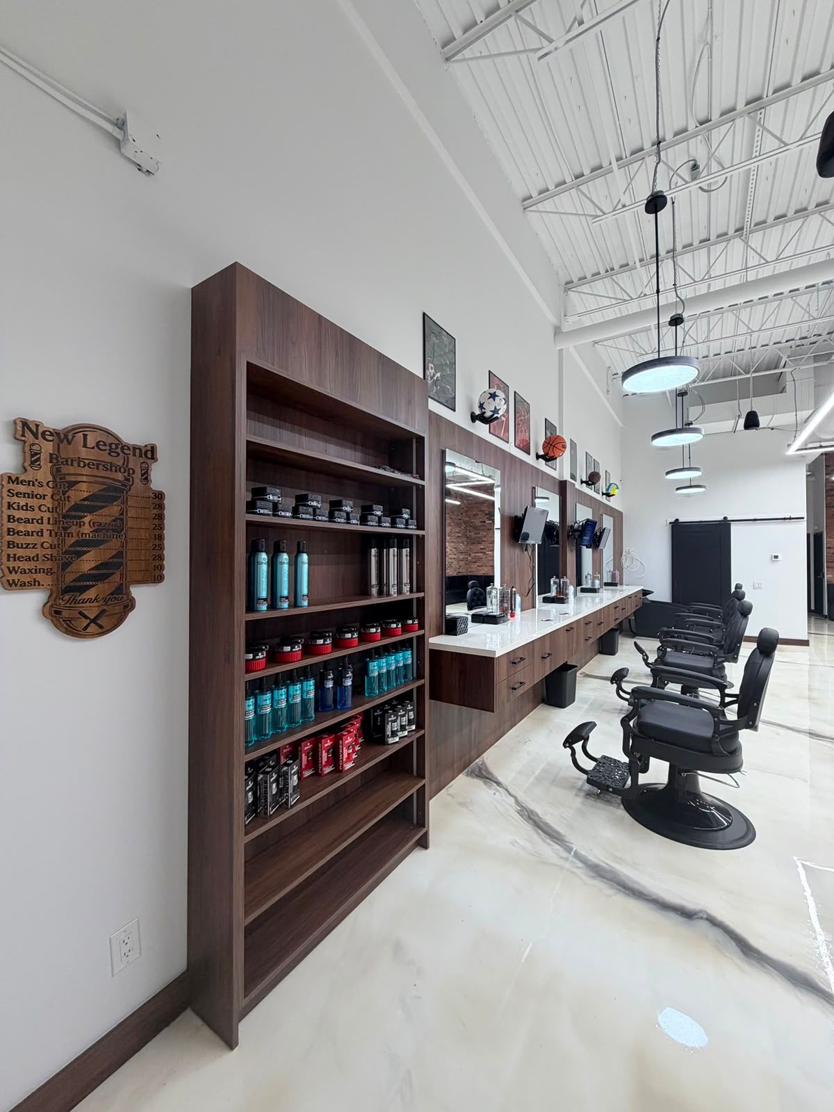 Walnut shelf stocked with hair styling and grooming products next to the carved wooden New Legend Barbershop sign in Hamilton